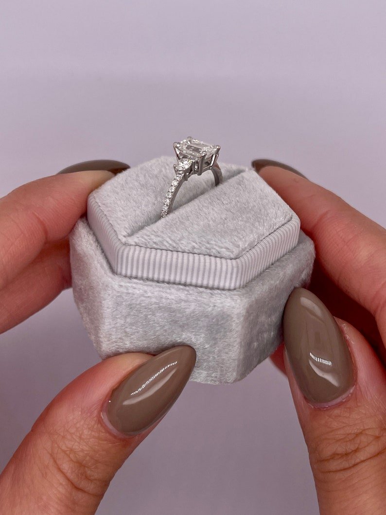 Profile view of emerald cut three stone engagement ring band