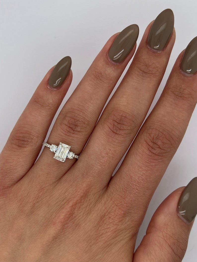 Side angle of emerald three stone diamond engagement ring