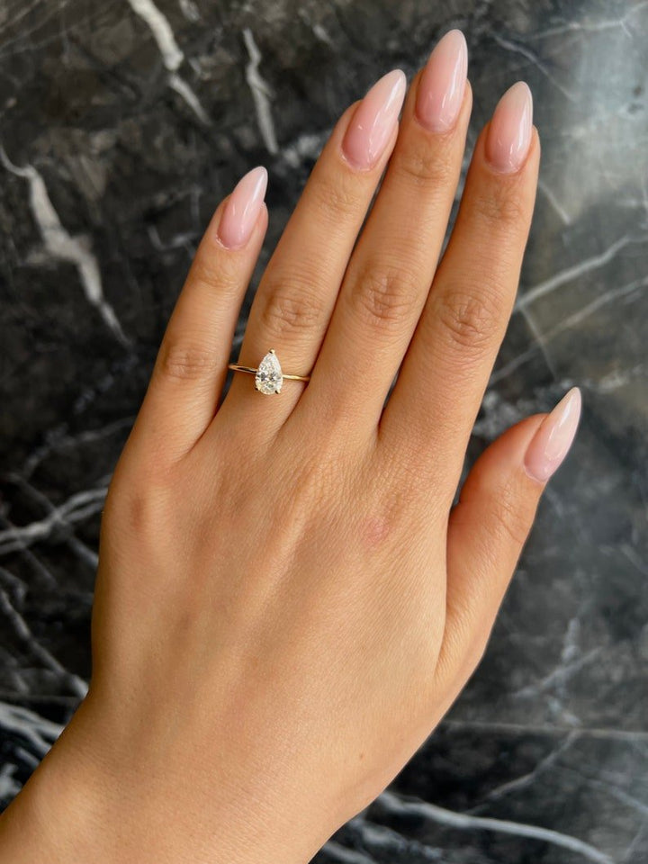 Pear solitaire engagement ring photographed in natural light