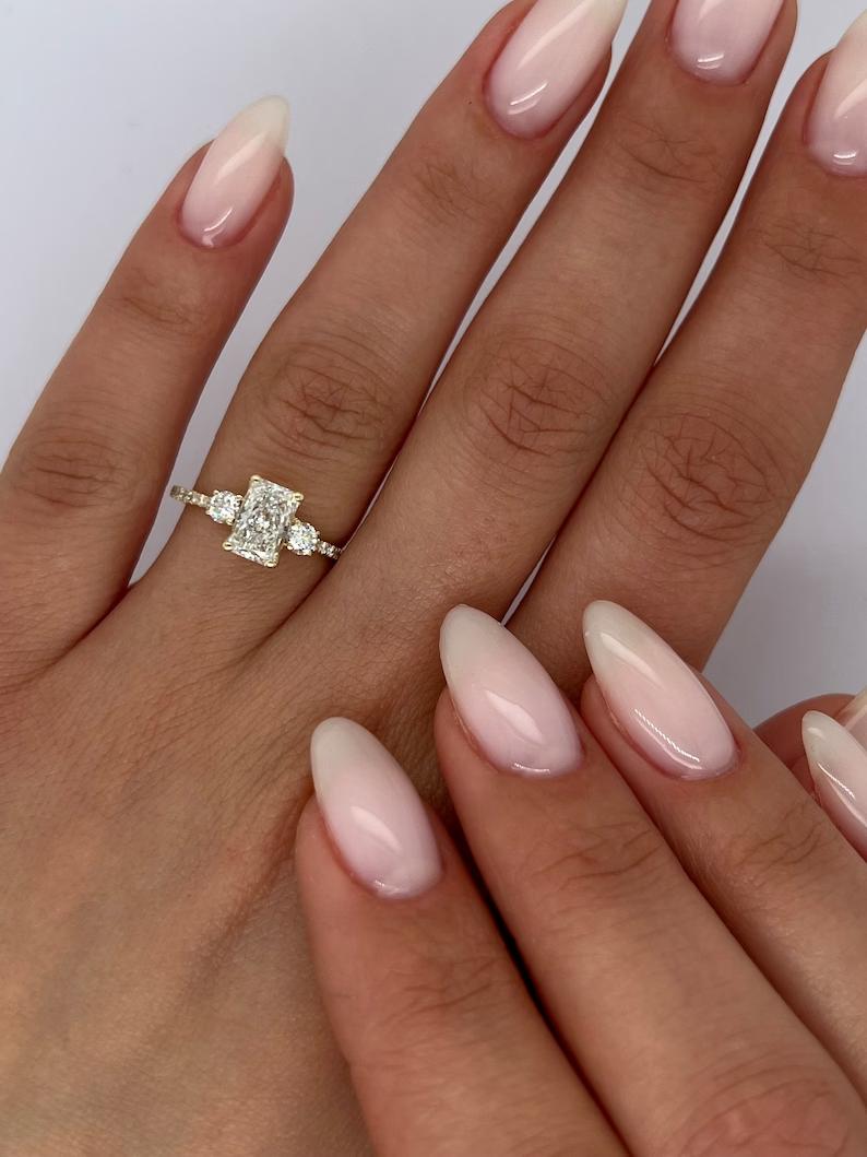 Radiant three stone diamond engagement ring available in multiple metals