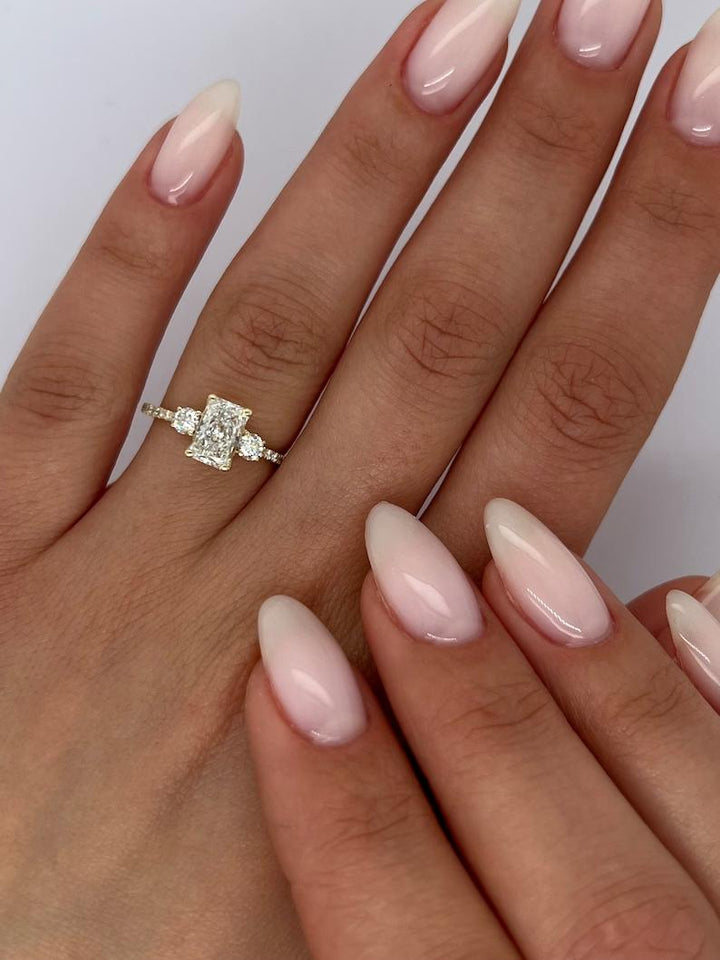 Radiant three stone diamond engagement ring available in multiple metals
