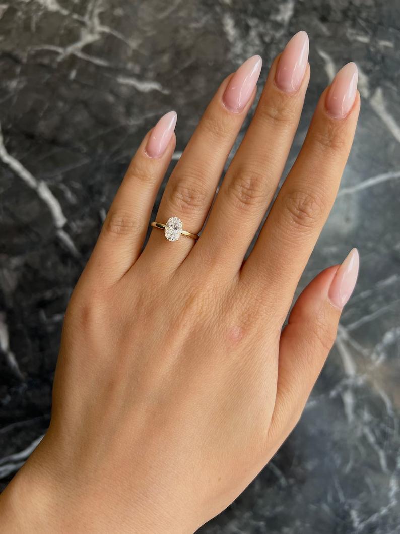 Oval cut engagement ring shown with authenticity certificate
