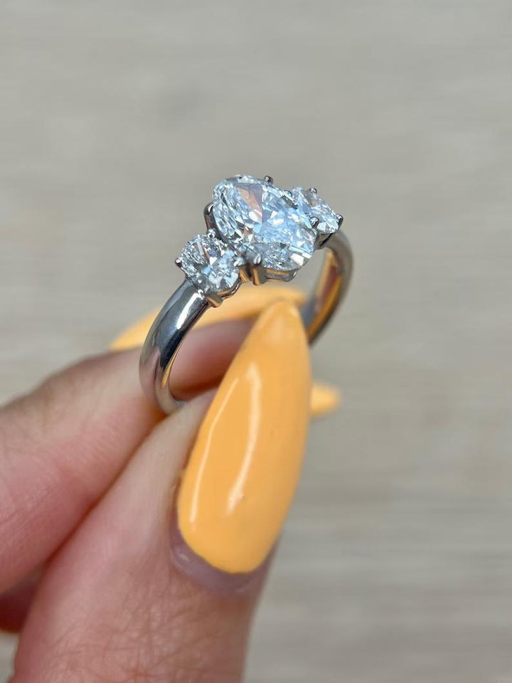 IGI certified oval cut diamond in three stone engagement ring setting