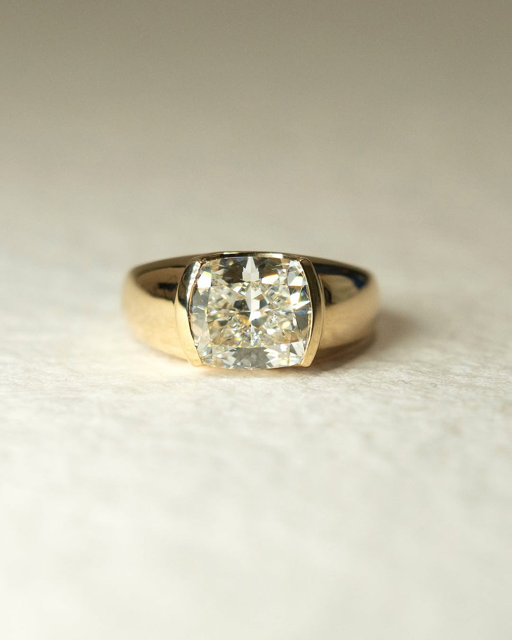 Angled view of cushion cut diamond in bezel setting