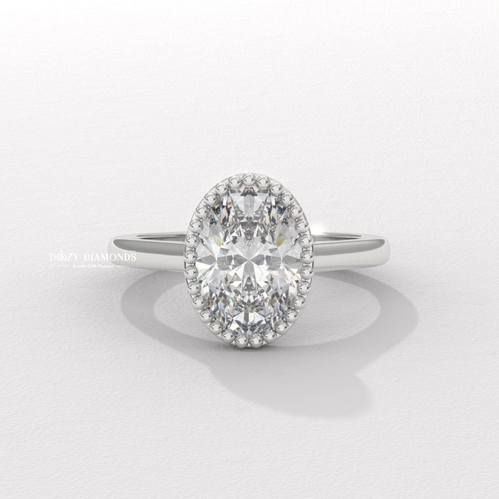Close-up of oval cut center diamond in bezel engagement ring
