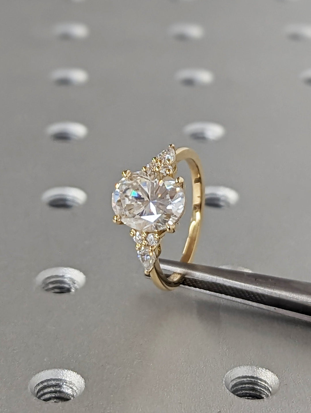 Oval cluster engagement ring viewed from the side