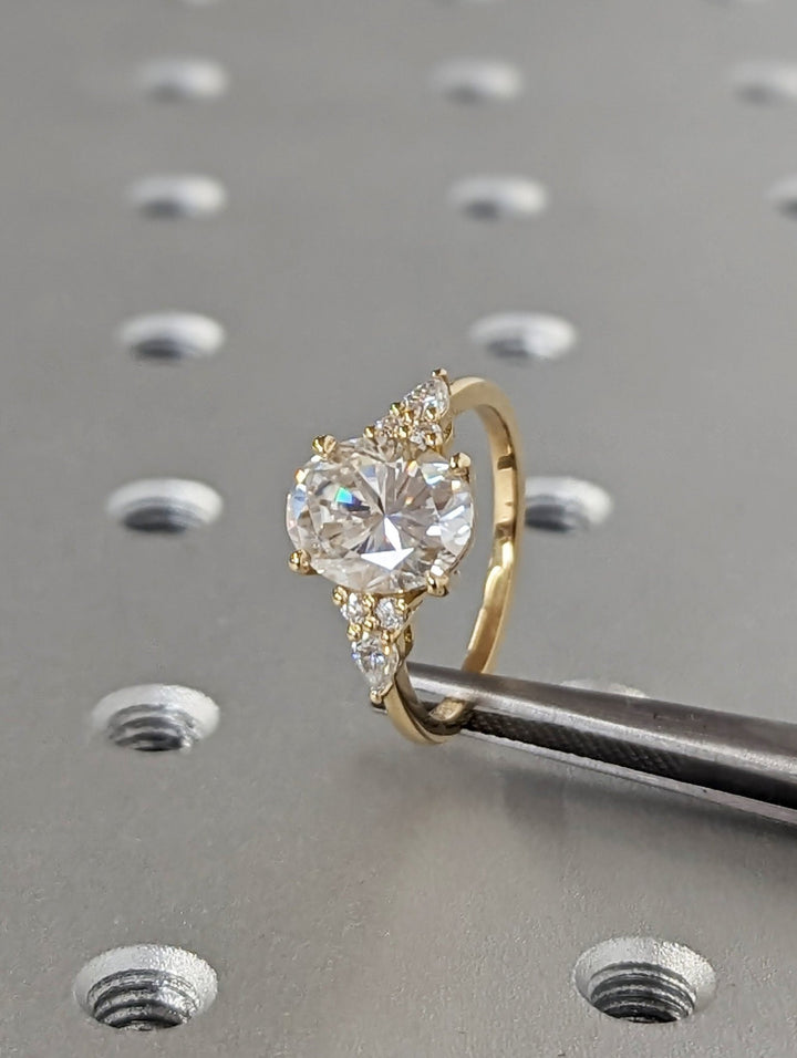 Oval cluster engagement ring viewed from the side