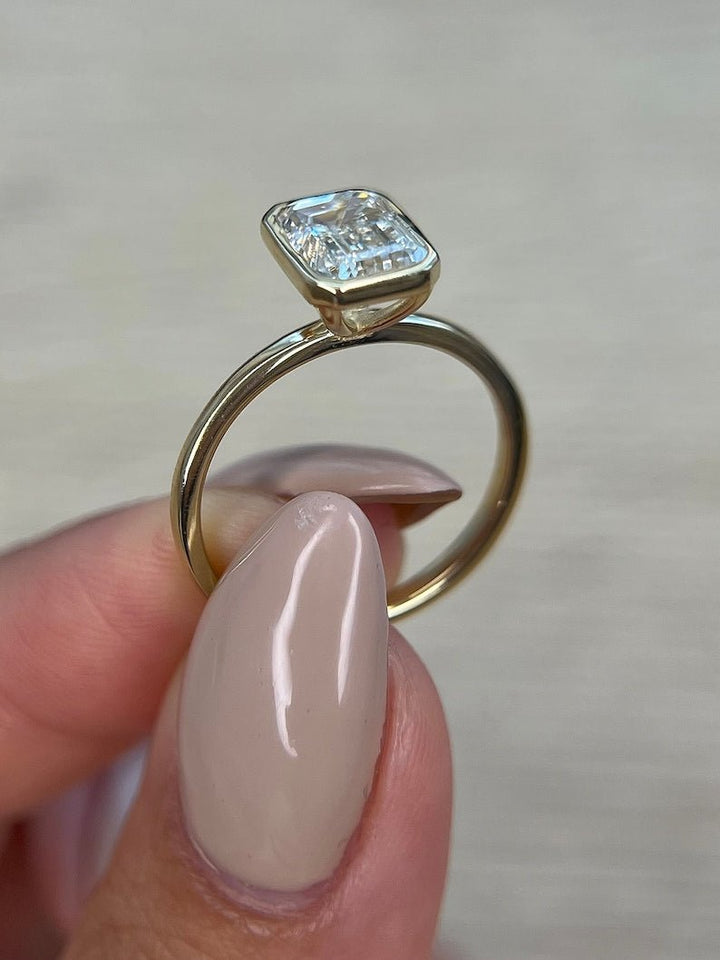 Emerald bezel engagement ring close-up highlighting diamond sparkle