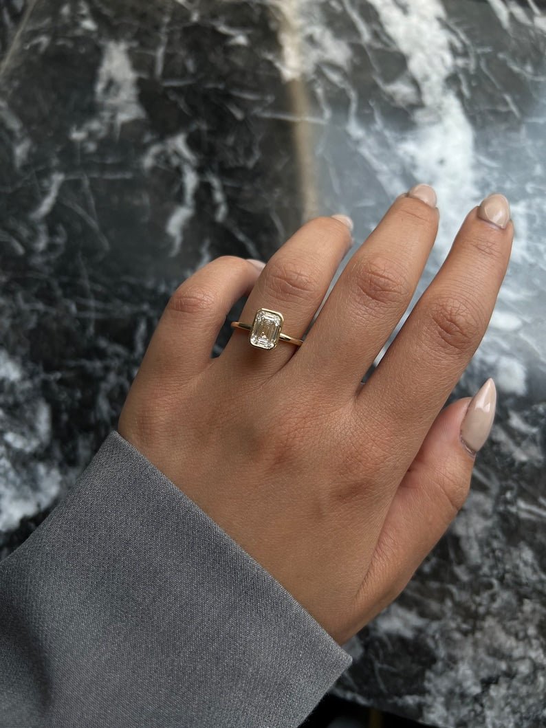 Angled view of emerald cut diamond in bezel setting