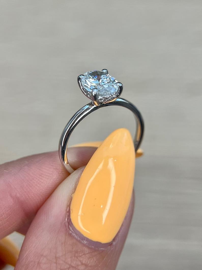 Oval hidden halo diamond ring presented in signature gift packaging