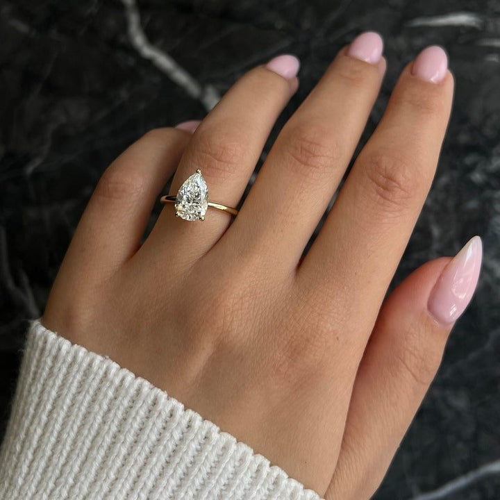 Pear solitaire diamond ring displayed on jewelry stand