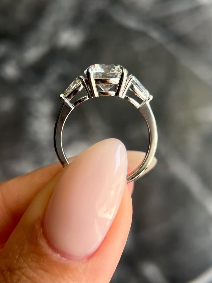 Top-down view of round cut three stone engagement ring