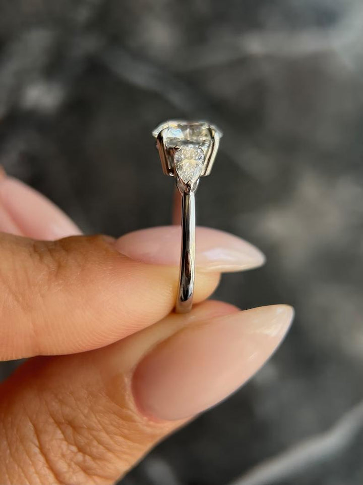 Round three stone engagement ring photographed in natural light