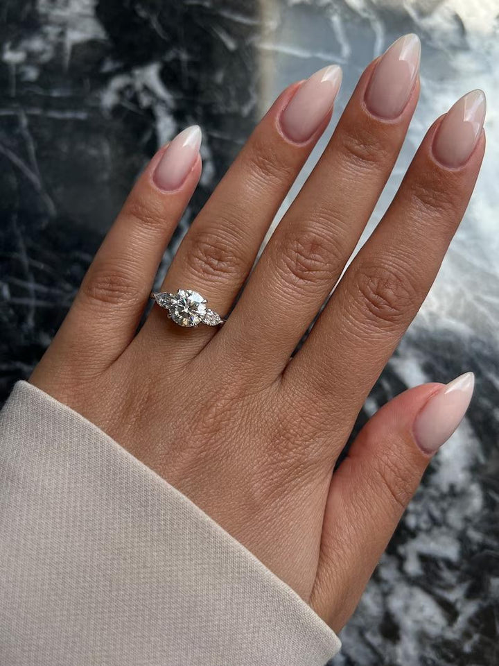 Round three stone engagement ring finished in polished solid gold