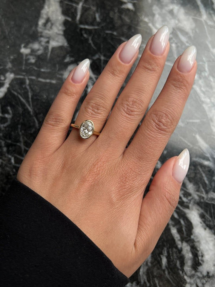 Oval bezel engagement ring photographed in natural light
