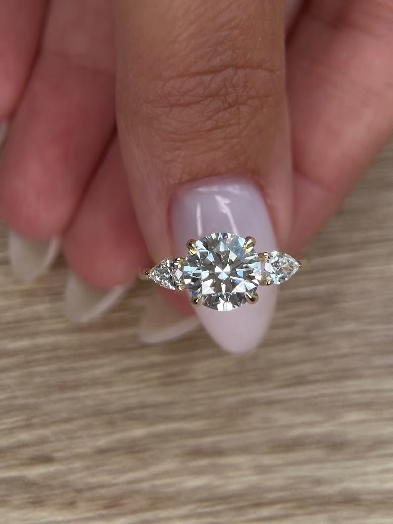 Macro shot of round cut diamond facets in three stone ring setting