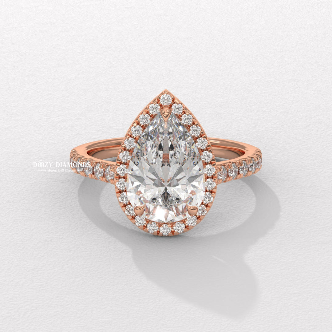 Close-up of pear cut center diamond in halo engagement ring