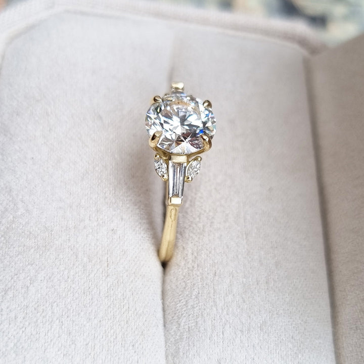 Round cluster engagement ring shown on hand for true-to-life sizing