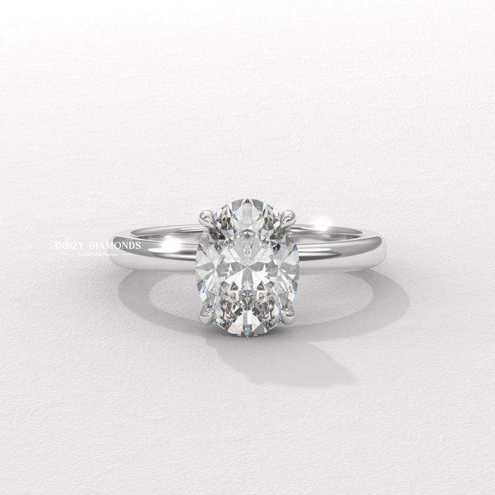 Oval hidden halo engagement ring viewed from the side