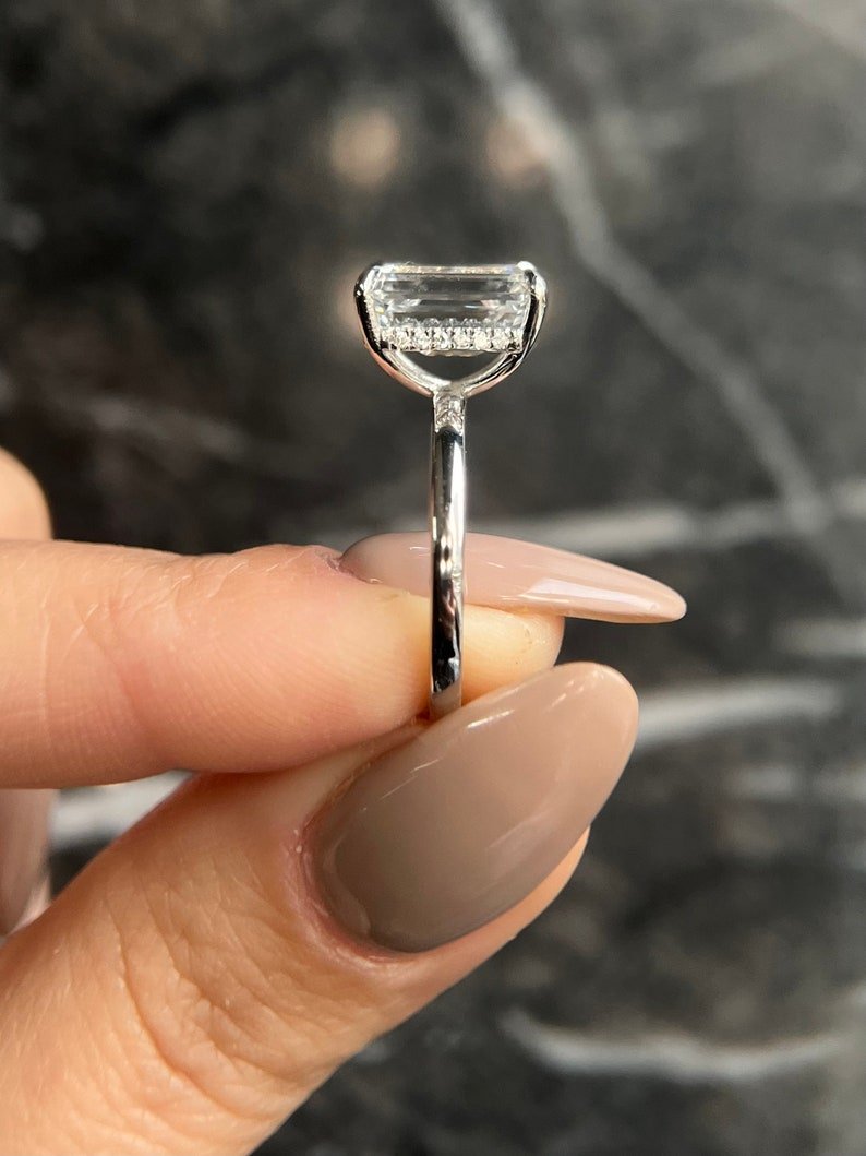 Side angle of emerald hidden halo diamond engagement ring