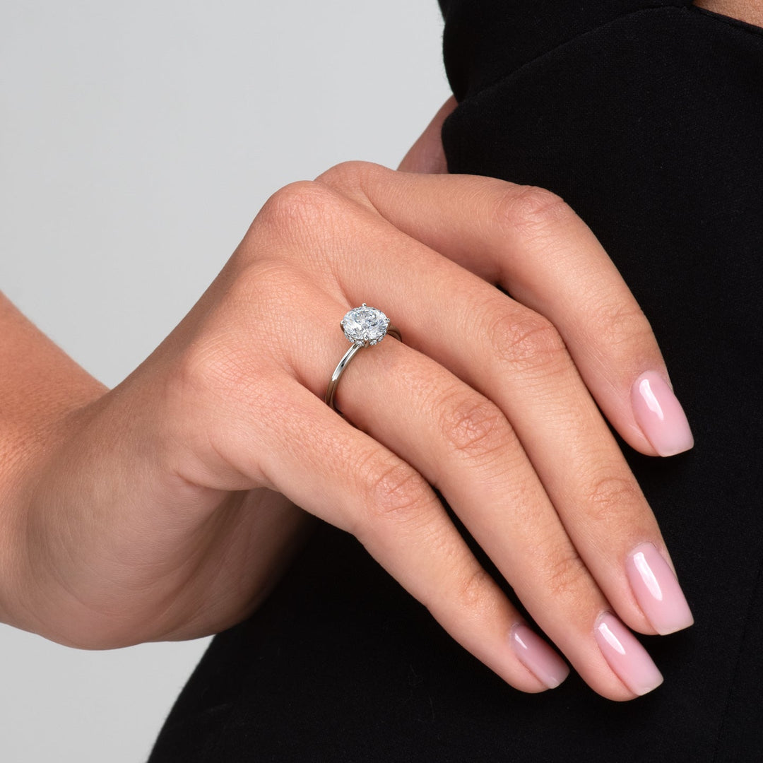 Round cut hidden halo engagement ring shown in real-life wear