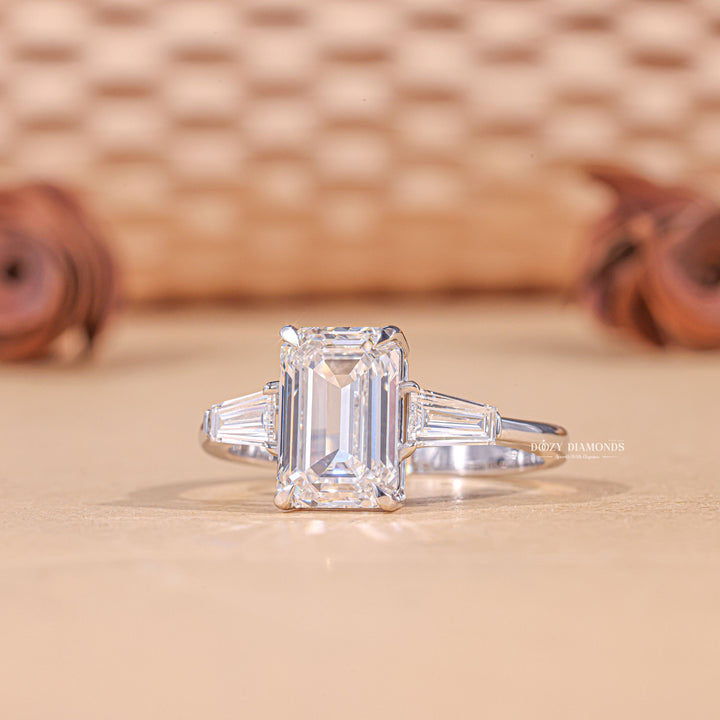 Unboxing view of emerald cut three stone diamond engagement ring
