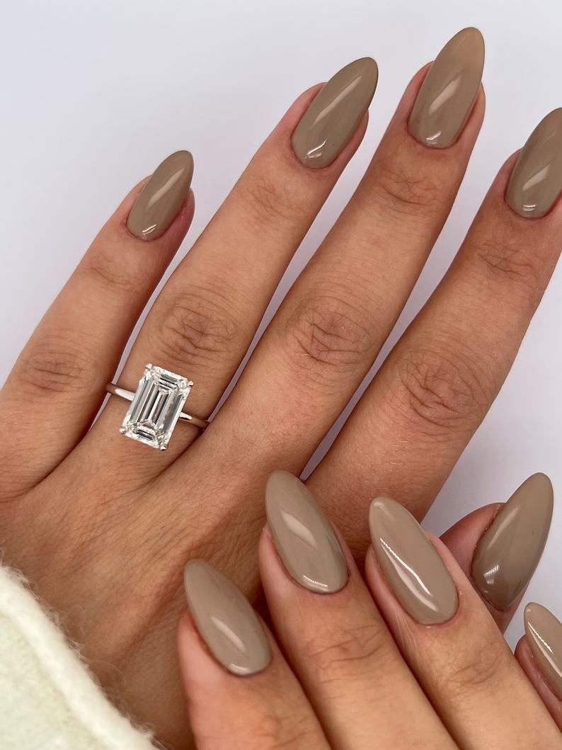 Unboxing view of emerald cut solitaire diamond engagement ring