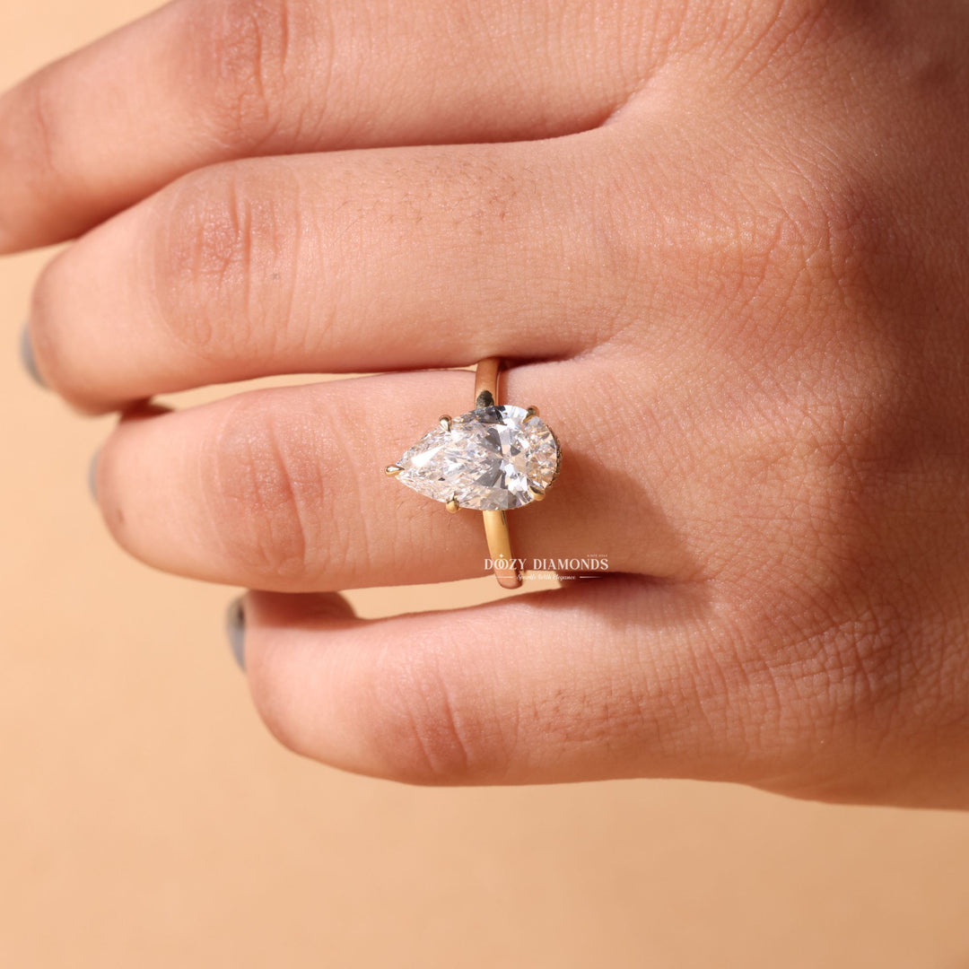 Pear hidden halo diamond ring displayed on jewelry stand
