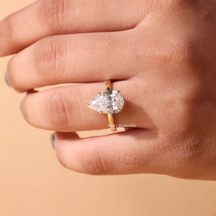 Pear hidden halo diamond ring displayed on jewelry stand