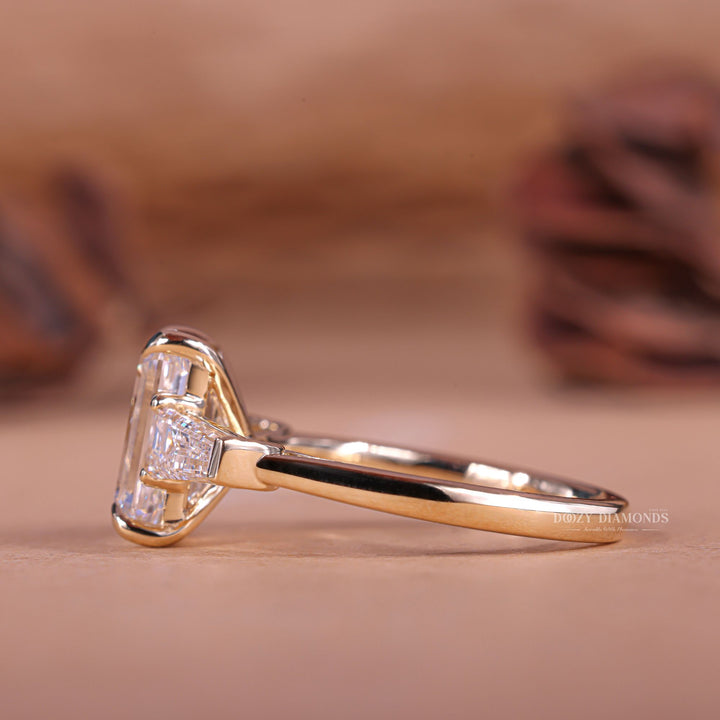 Emerald cut three stone engagement ring shown in real-life wear