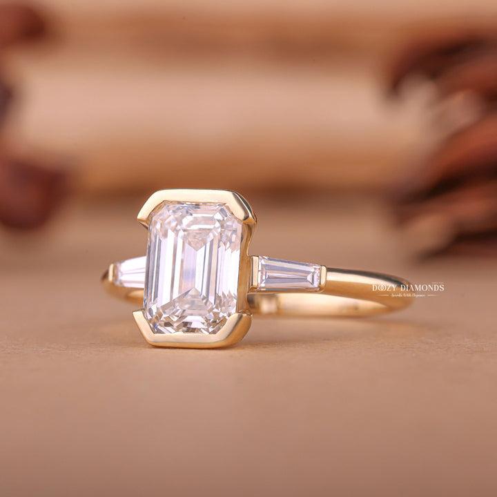 Emerald three stone engagement ring close-up highlighting diamond sparkle