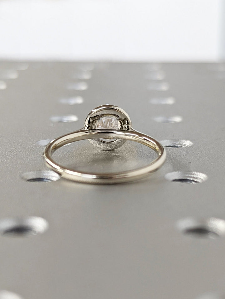 Macro shot of round cut diamond facets in halo ring setting