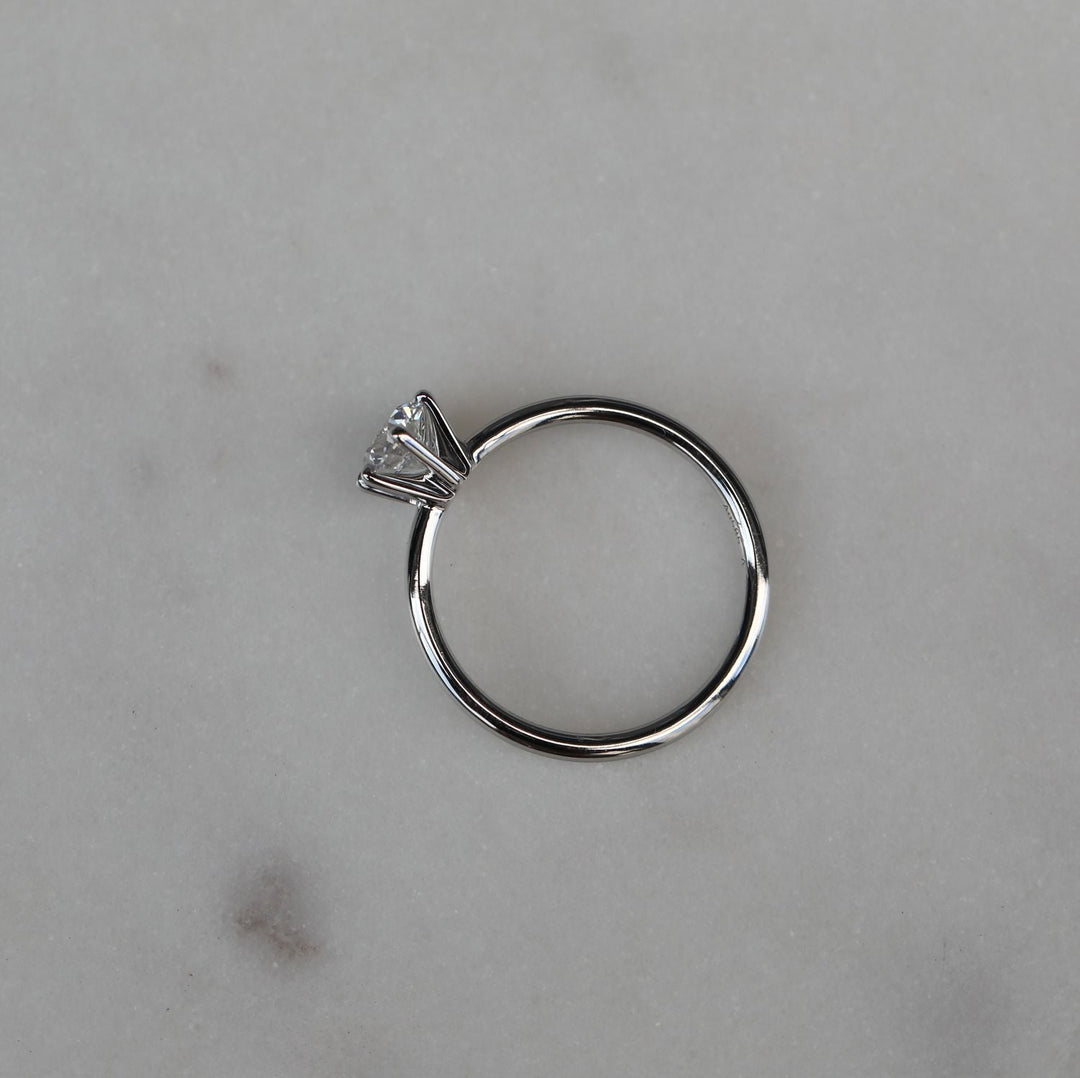 Round cut engagement ring shown with authenticity certificate