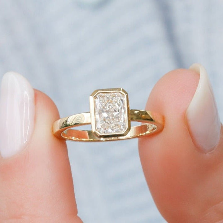 Close-up of radiant cut center diamond in bezel engagement ring