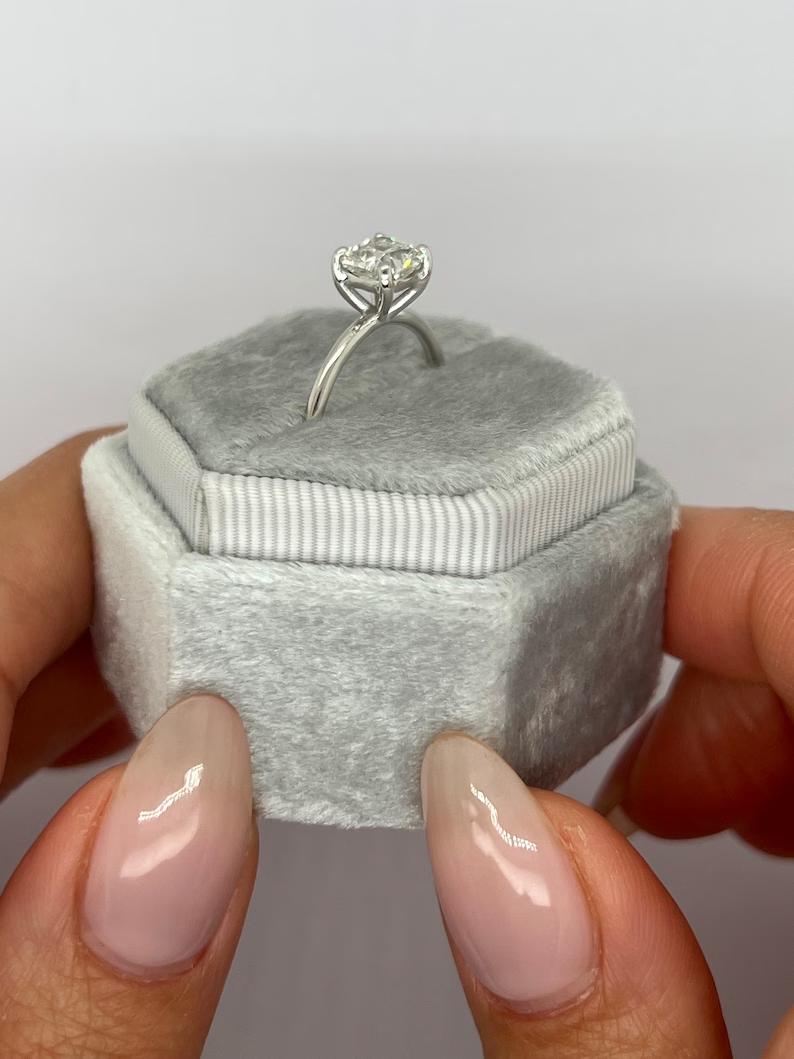 Cushion cut solitaire engagement ring shown in real-life wear