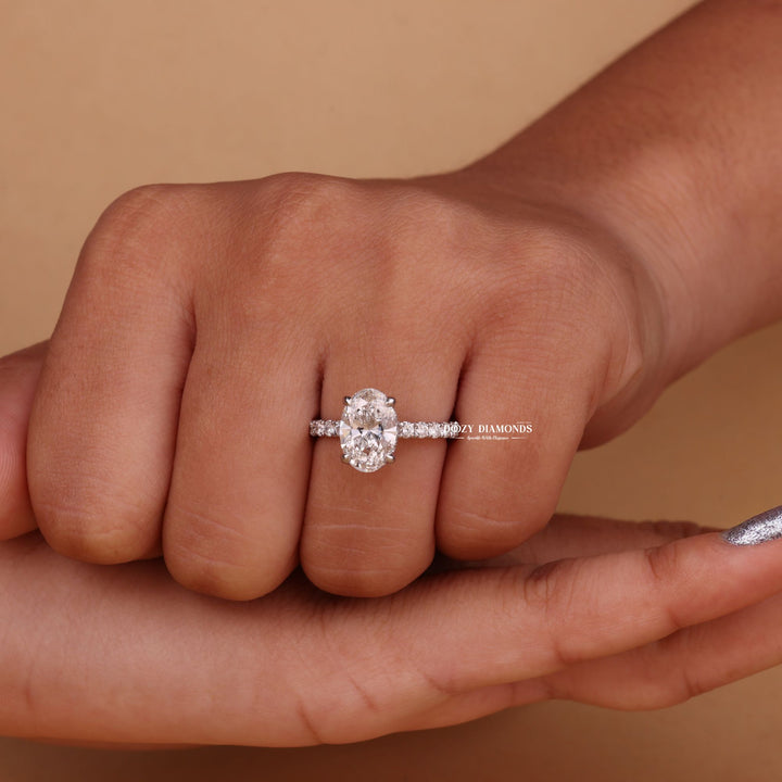 Detailed close-up of oval hidden halo diamond engagement ring