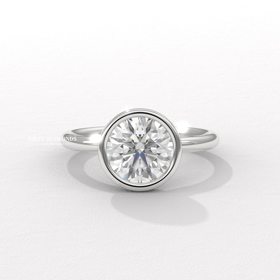 Round bezel engagement ring offered in gold and platinum