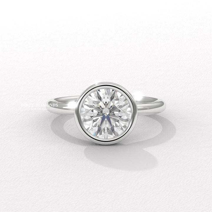 Round bezel engagement ring offered in gold and platinum