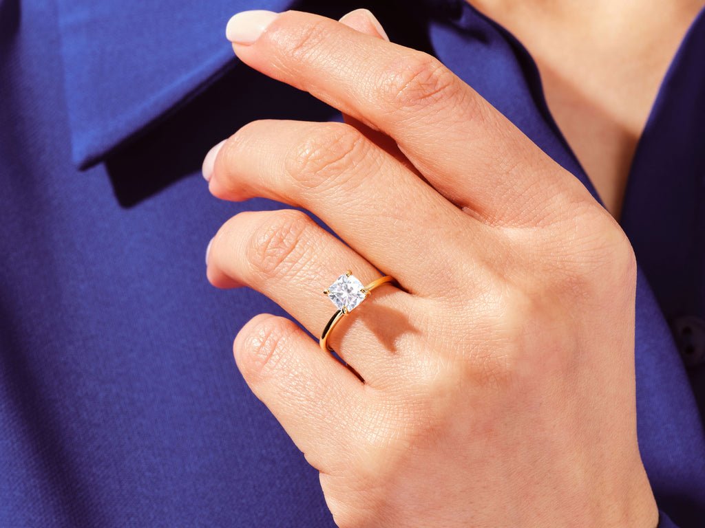Cushion solitaire engagement ring shown on hand for true-to-life sizing