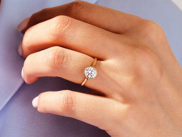 Round bezel diamond engagement ring available in multiple metals