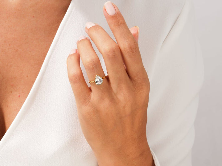 Pear bezel ring set with an IGI graded diamond