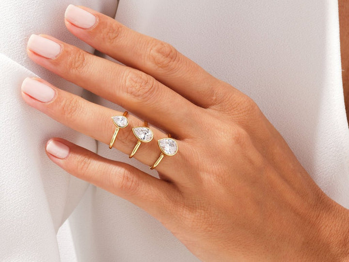 Certified pear cut diamond featured in bezel engagement ring