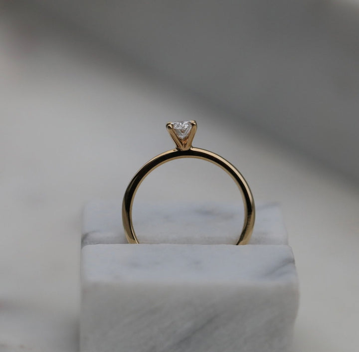 Oval solitaire diamond ring displayed on jewelry stand