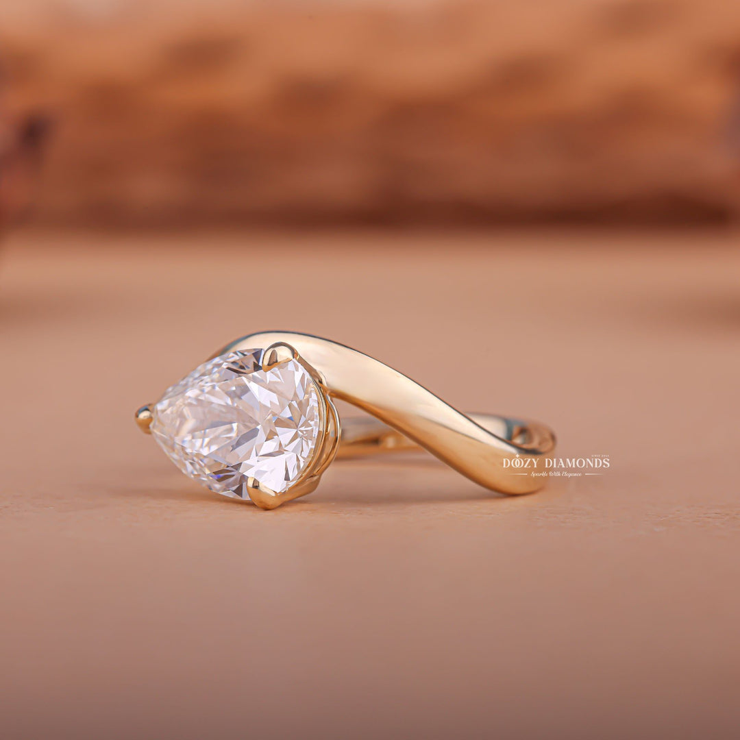 Pear east west diamond ring displayed on jewelry stand