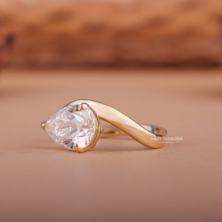 Pear east west diamond ring displayed on jewelry stand
