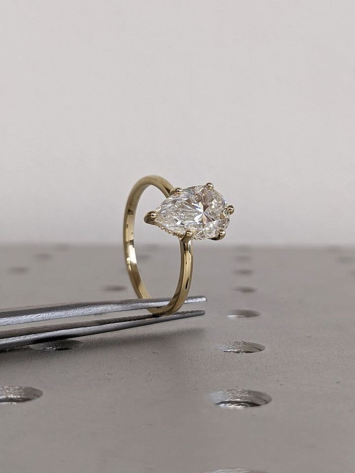 Pear hidden halo lab grown diamond ring side profile in gold setting