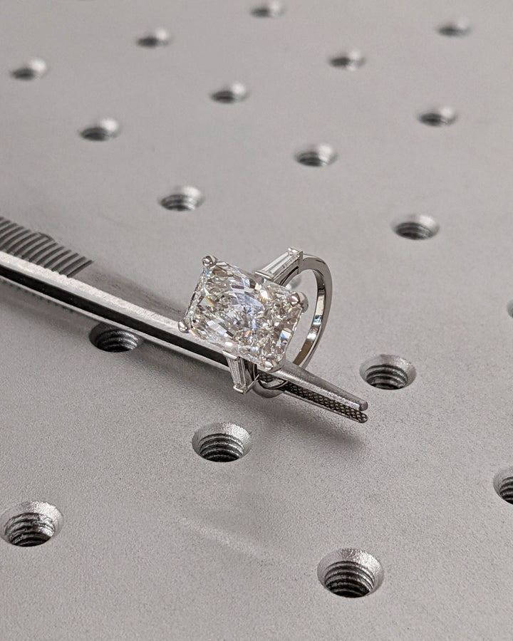 Close-up of radiant cut center diamond in three stone engagement ring