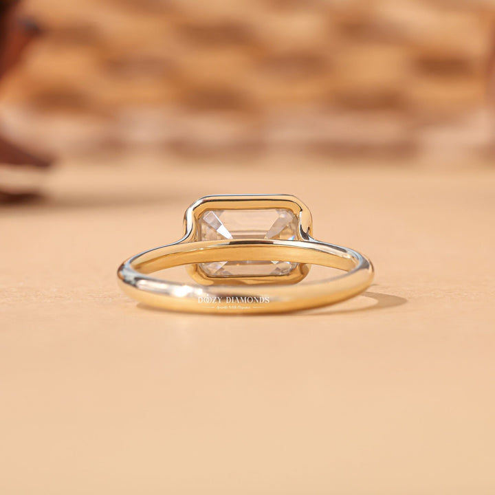 Emerald bezel engagement ring shown on hand for true-to-life sizing