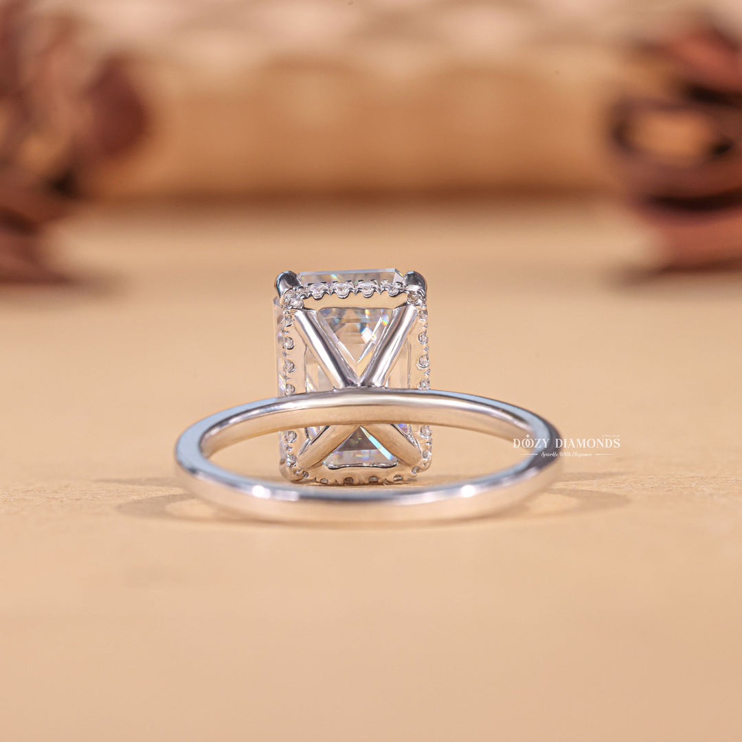 Emerald hidden halo engagement ring shown on hand for true-to-life sizing