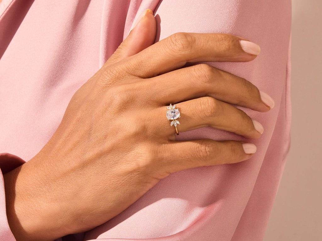 Oval cluster engagement ring shown on hand for true-to-life sizing